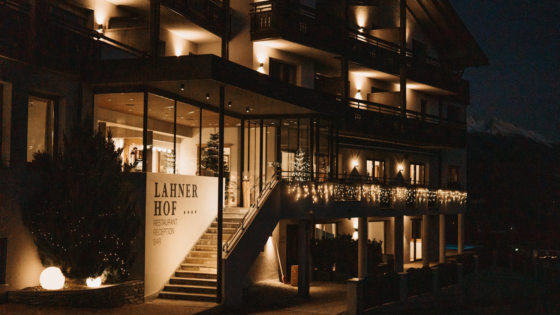 Lahnerhof: Natur- und Wellnesshotel bei Sterzing Beleuchteter Eingang des Hotels Lahnerhof bei Nacht mit Weihnachtsbeleuchtung