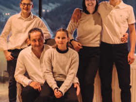 Lahnerhof: our nature and wellness hotel near Sterzing Six smiling family members in front of window with mountain view