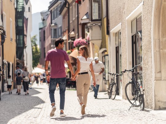 Hiking in Ratschings and surroundings Couple holding hands walking down a busy city street on a sunny day