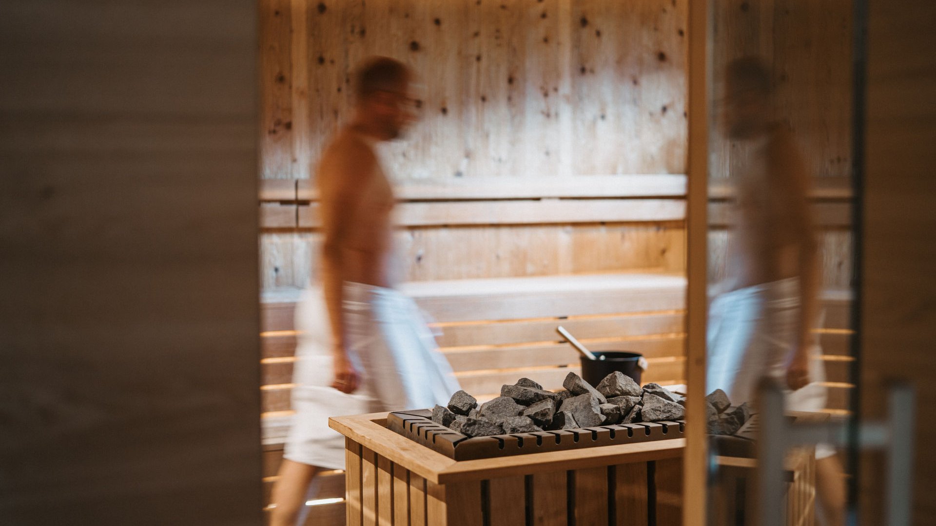Lahnerhof: our nature and wellness hotel near Sterzing Man with towel in sauna next to heater with stones