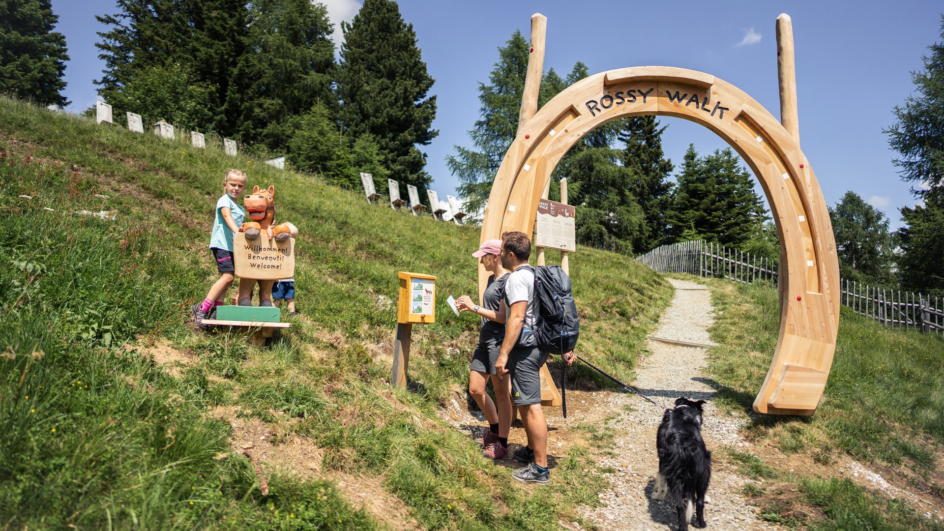 Hiking in Ratschings and surroundings Family with dog at entrance of Rossy Walk on a mountain trail
