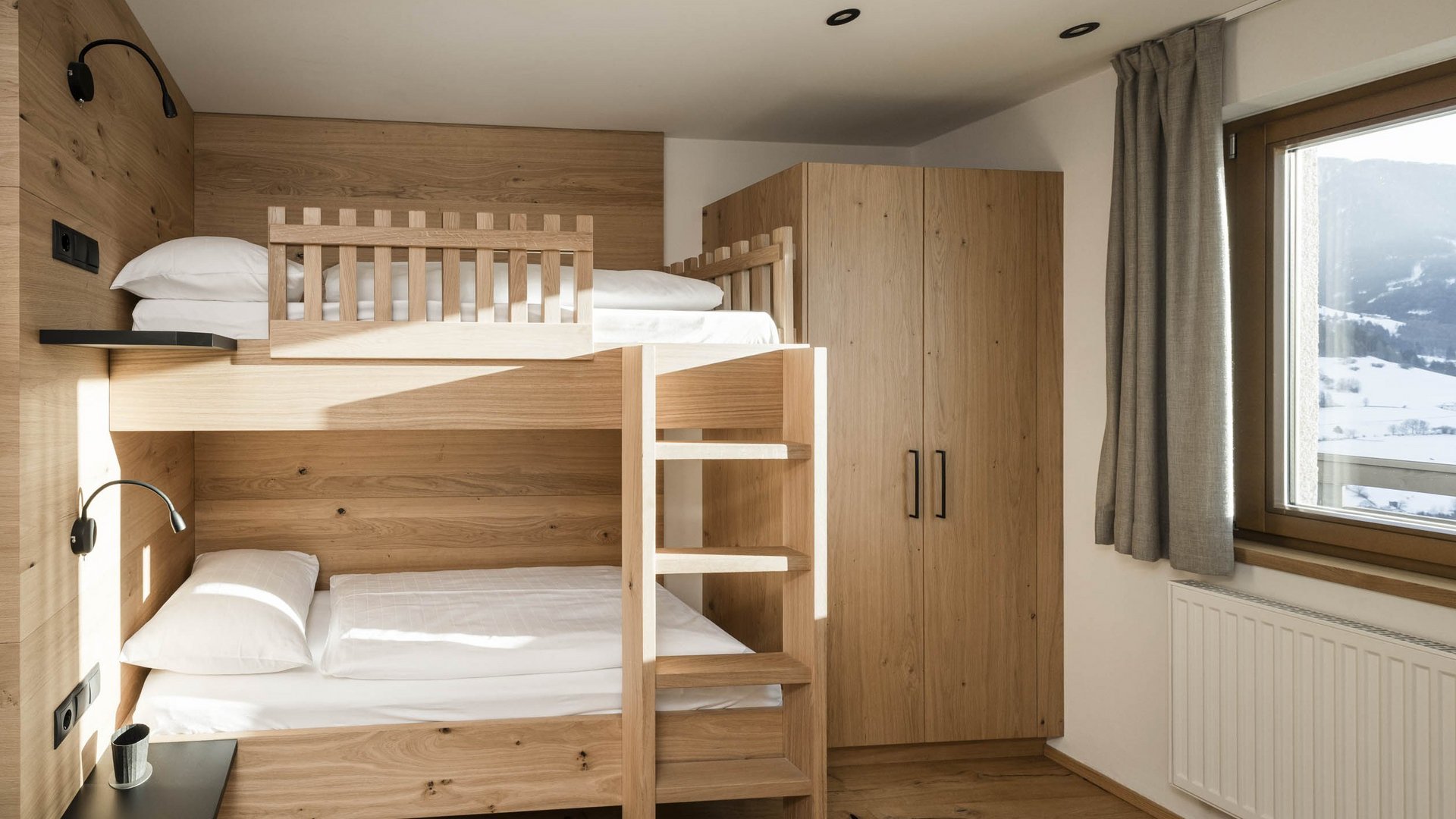 Holiday at Monte Cavallo/Rosskopf, Sterzing: hotel Lahnerhof Modern room with bunk bed and snowy mountain view through window