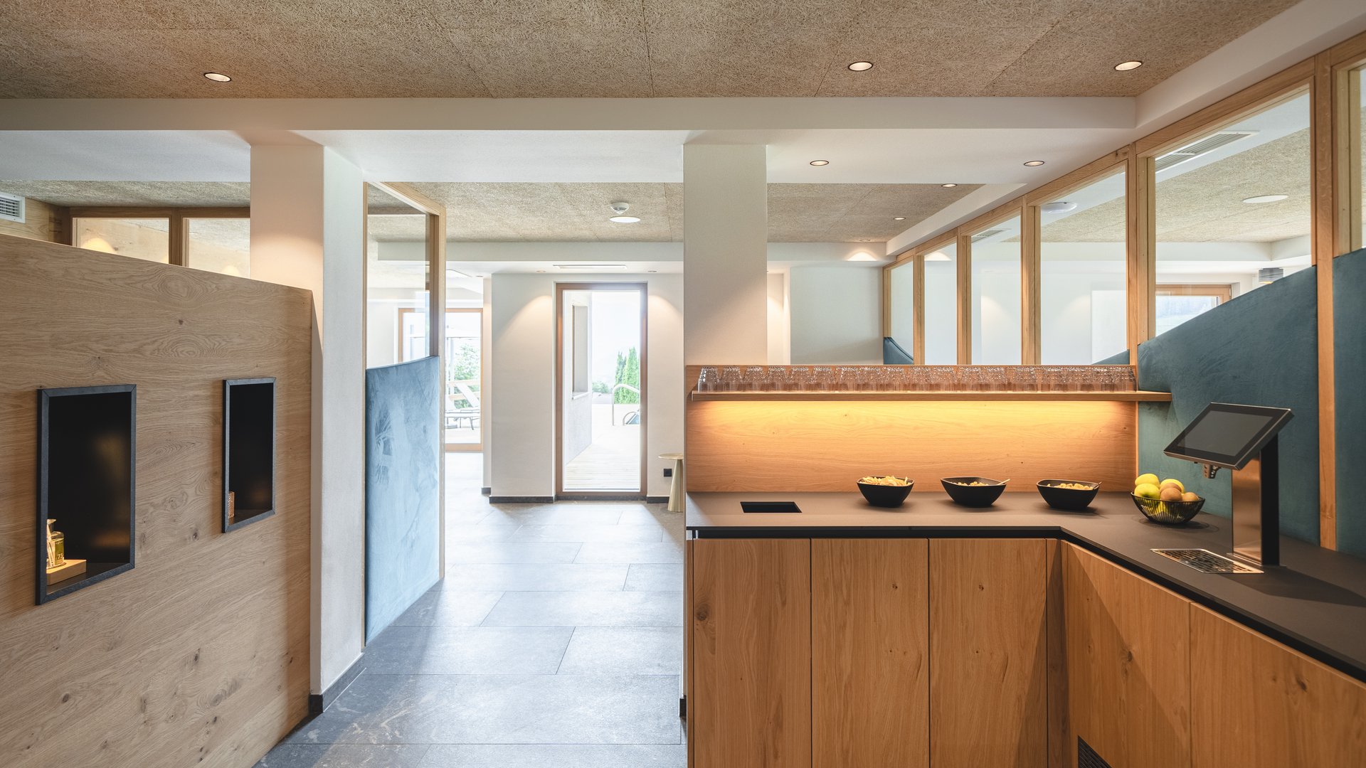 Our hiking and wellness hotel near Sterzing: Lahnerhof Modern lounge area with wooden counter, snacks, and outdoor terrace access