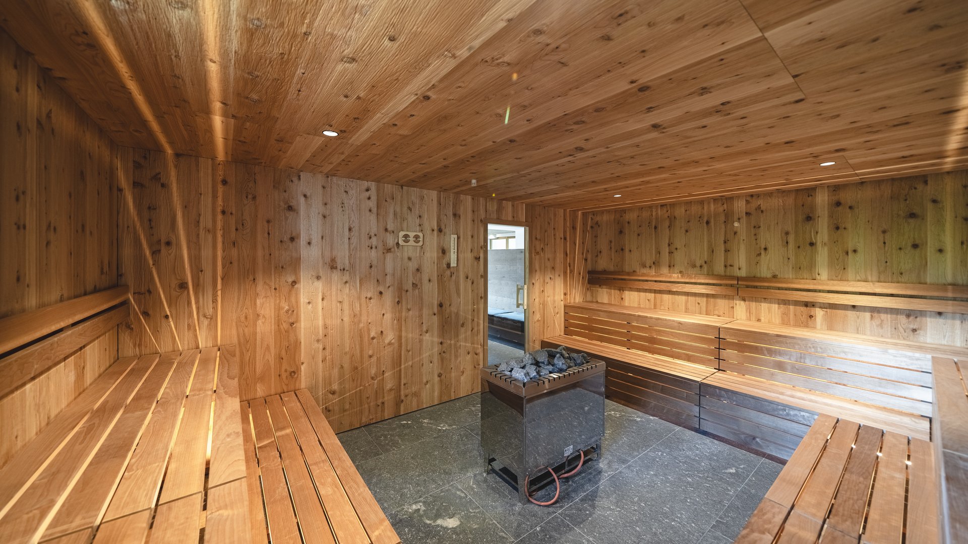 Our hiking and wellness hotel near Sterzing: Lahnerhof interior of a sauna with wooden walls and central stove