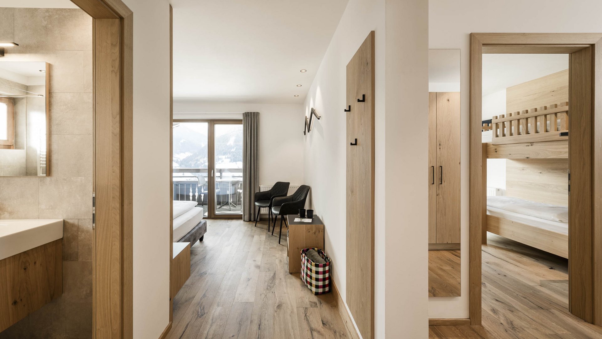 Vacanze al Monte Cavallo: eccovi all’Hotel Lahnerhof! Corridoio luminoso con pavimento in legno, vista su camera da letto e balcone con vista montagne
