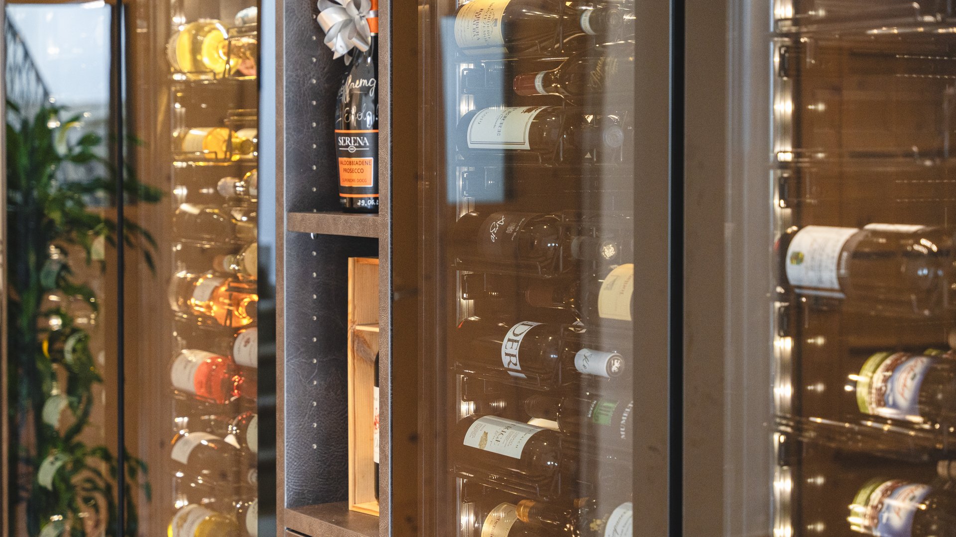 South Tyrolean specialities at our restaurant near Sterzing Wine coolers with assorted wine bottles in a modern setting