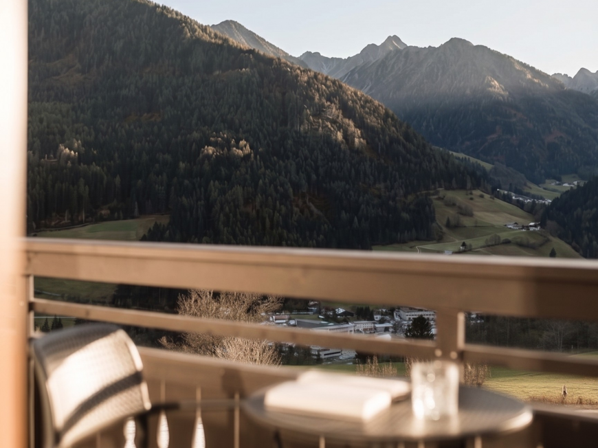 Holiday at Monte Cavallo/Rosskopf, Sterzing: hotel Lahnerhof Mountain landscape with forest and valley viewed from a balcony with chair and table