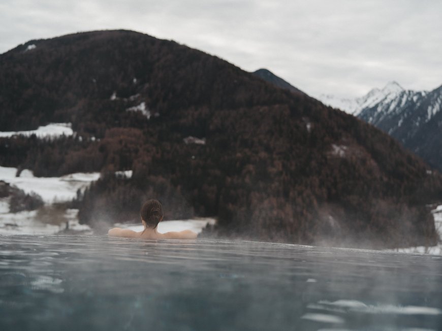 Wander- und Wellnesshotel bei Sterzing: der Lahnerhof Person entspannt in einem beheizten Außenpool mit Bergblick