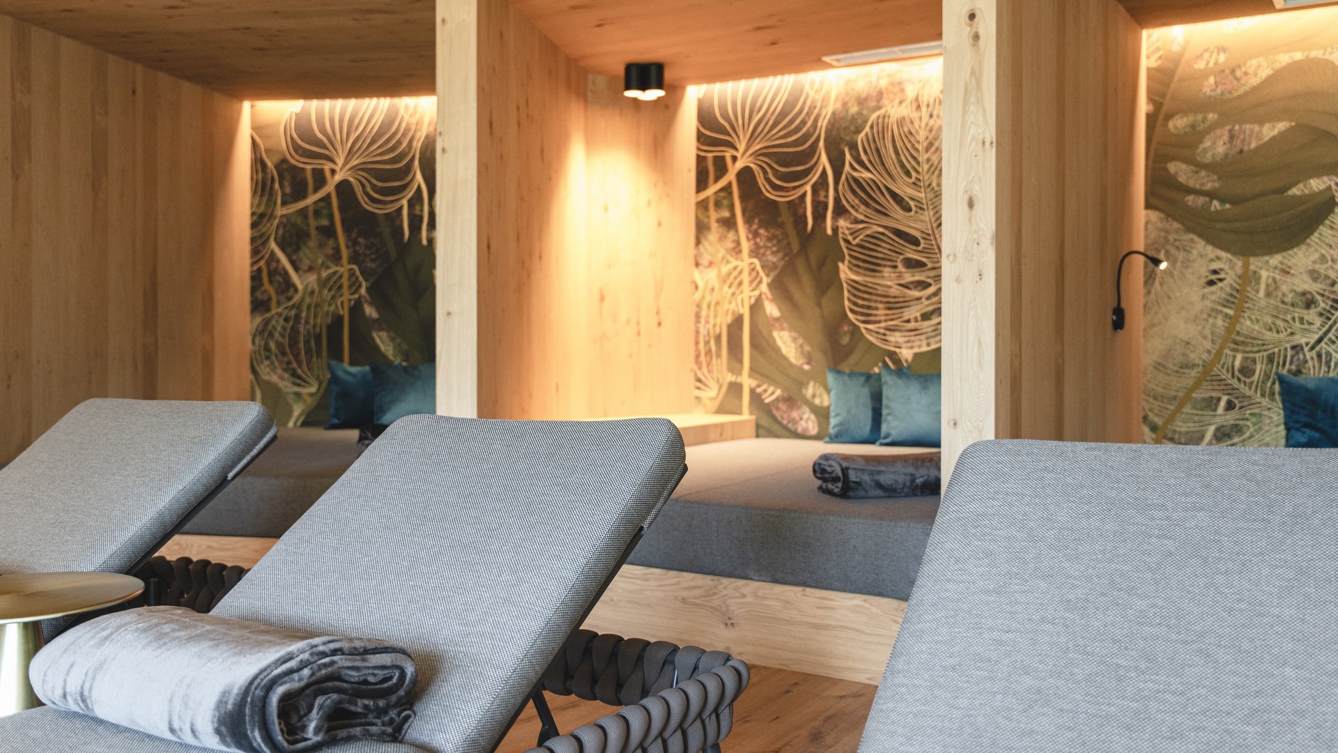 Lahnerhof: Natur- und Wellnesshotel bei Sterzing Gemütlicher Ruheraum mit Liegestühlen und Holzkabinen mit Pflanzenmotiven