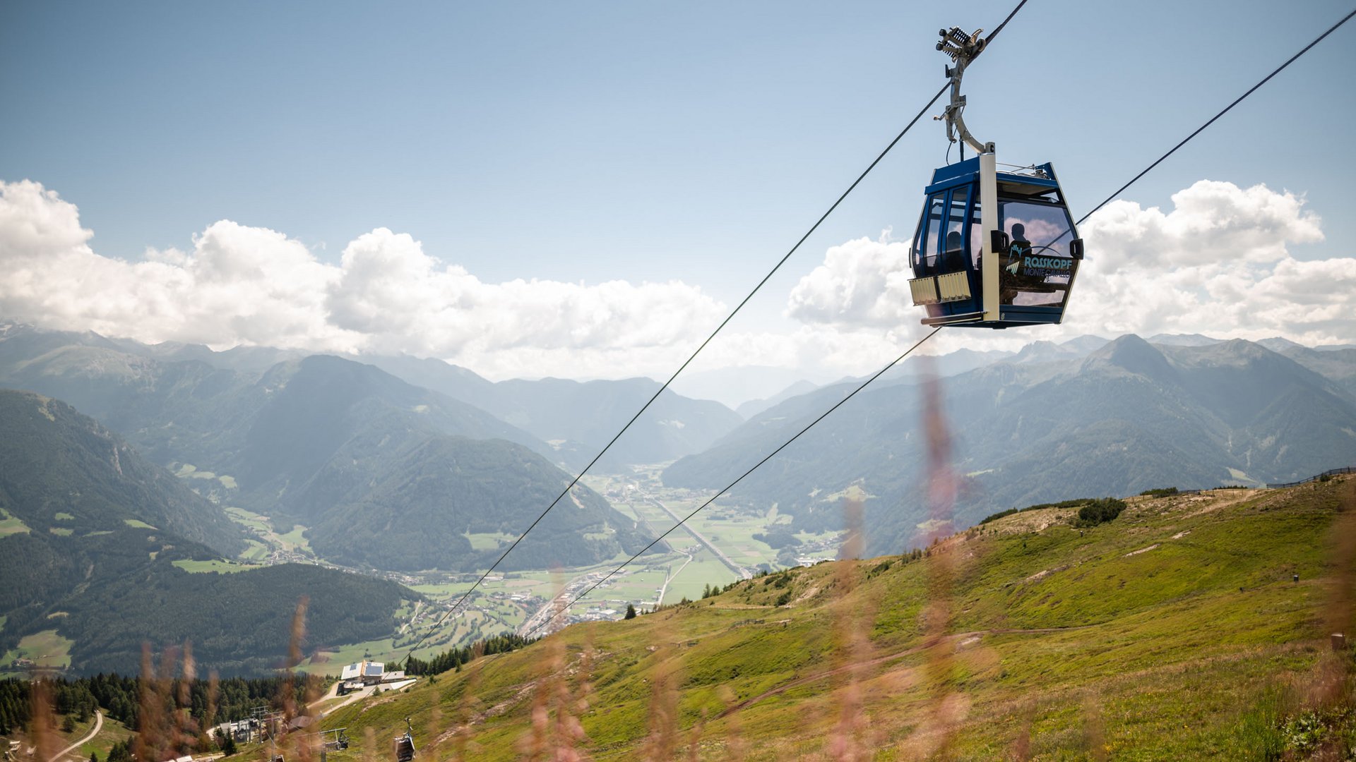 Vi piacciono le escursioni con le ciaspole a Vipiteno? Funivia con vista sulla valle e le montagne sotto il cielo soleggiato