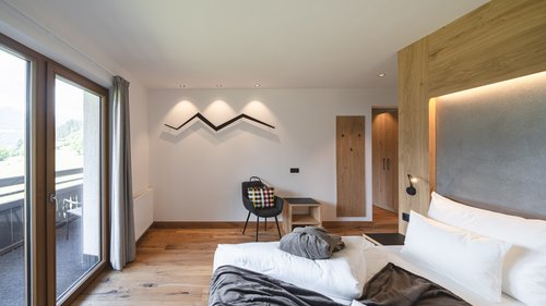 Lahnerhof, Ihr Hotel bei Sterzing Hell eingerichtetes Hotelzimmer mit Balkon und Holzfußboden