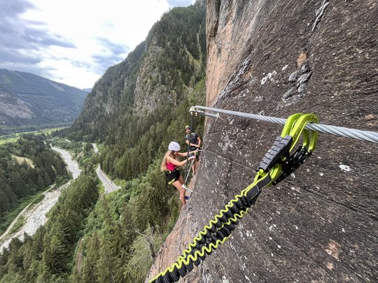 Hiking in Ratschings and surroundings Two climbers secured with carabiners and steel cable on a rock climbing wall