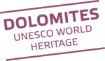 Scritta Dolomiti patrimonio mondiale UNESCO in viola