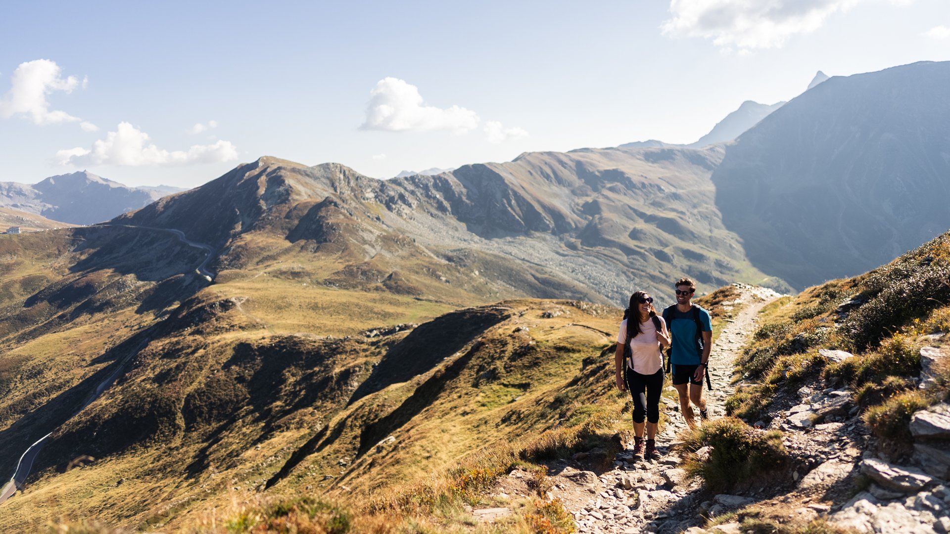 Wanderung auf den Rosskopf und mehr Zwei Wanderer gehen auf einem Bergpfad bei sonnigem Himmel