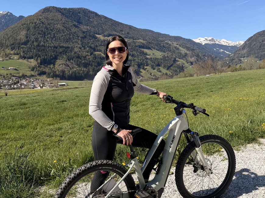 Wanderung auf den Rosskopf und mehr Frau mit Fahrrad vor Berglandschaft bei klarem Himmel