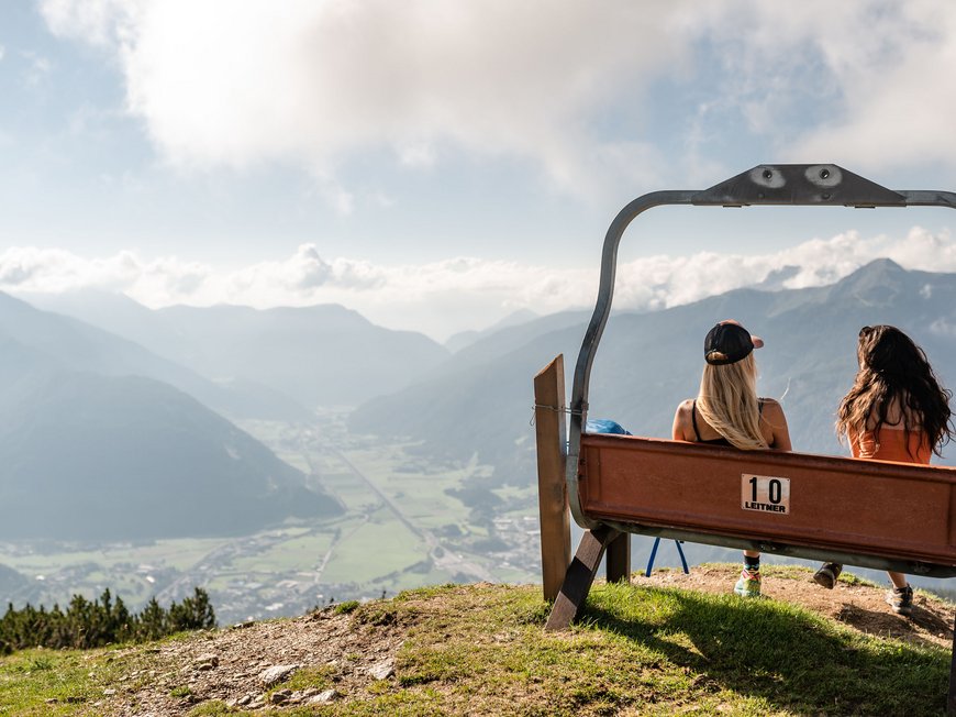 Lahnerhof: our nature and wellness hotel near Sterzing Two women sit on a bench overlooking the mountains and valley