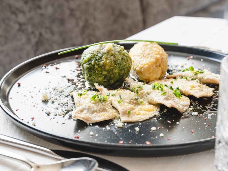 Lahnerhof, your hotel near Sterzing Bavarian dumplings with sauce and herbs on a black plate