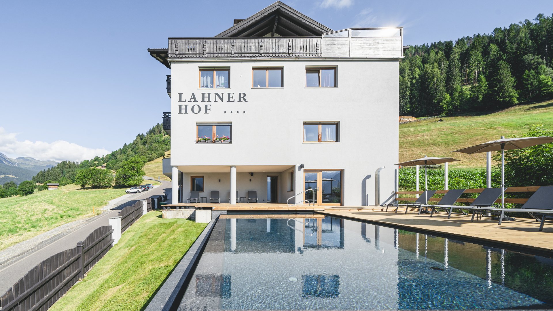 Lahner Hof Hotel mit Außenpool in bergiger Landschaft